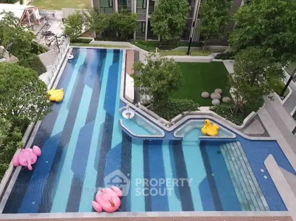 Luxurious residential pool with vibrant inflatable toys and lush greenery