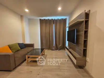 Modern living room with sleek TV unit and cozy sofa in stylish apartment.