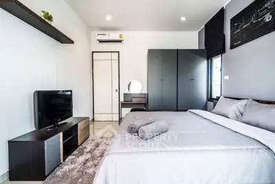 Modern bedroom with sleek furniture and cozy ambiance, featuring a stylish wardrobe and a comfortable bed.