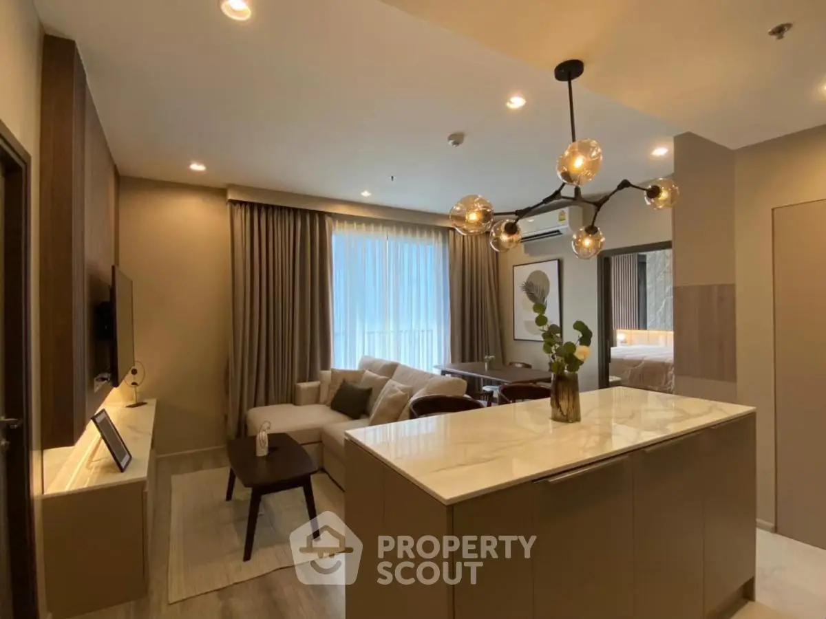 Modern open-layout living room with stylish lighting and cozy seating area