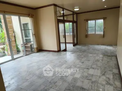 Spacious empty living room with marble flooring and large windows