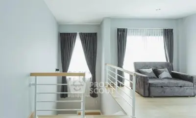 Modern interior with cozy seating area and stylish railing, perfect for relaxation and comfort.