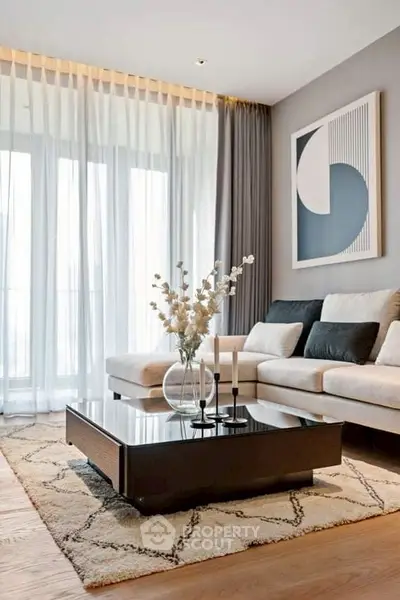 Elegant living room with modern decor, featuring a cozy sofa, stylish coffee table, and large window with sheer curtains.