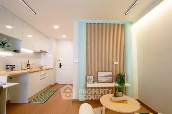 Modern open-layout kitchen and living area with stylish decor and warm lighting.