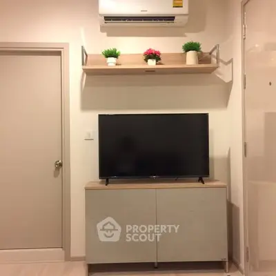 Modern living room with TV and air conditioner, stylish shelving and decor.