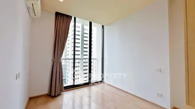 Bright empty room with large window and city view, perfect for customization.