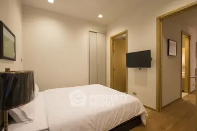 Cozy bedroom with modern decor and wall-mounted TV in a stylish apartment.