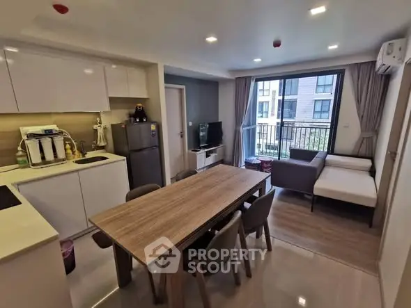 Modern open-plan kitchen and living room with natural light and stylish decor.