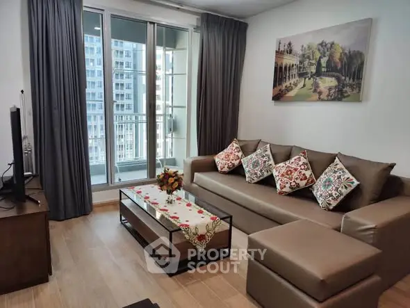 Modern living room with stylish decor and balcony view in a high-rise apartment.