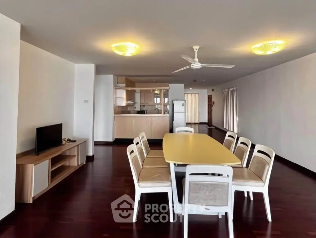 Spacious open-plan living and dining area with modern furnishings and wooden flooring.