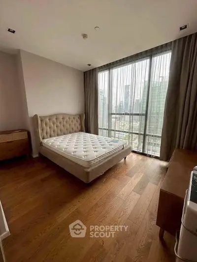 Spacious bedroom with city view and elegant hardwood flooring