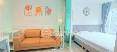 Modern studio apartment with stylish decor and glass partition separating living and sleeping areas.