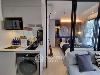 Modern studio apartment with open layout, featuring a compact kitchen and cozy living area.