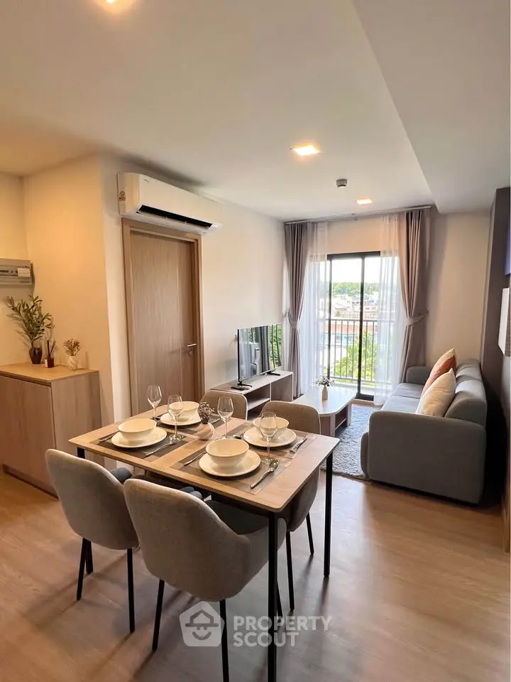 Modern living room with dining area and balcony view in a stylish apartment.