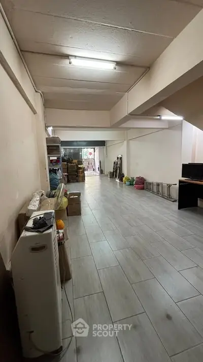 Spacious storage area with tiled flooring and ample lighting, ideal for business or personal use.