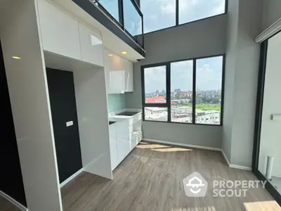 Modern loft apartment with high ceilings and large windows offering stunning city views.