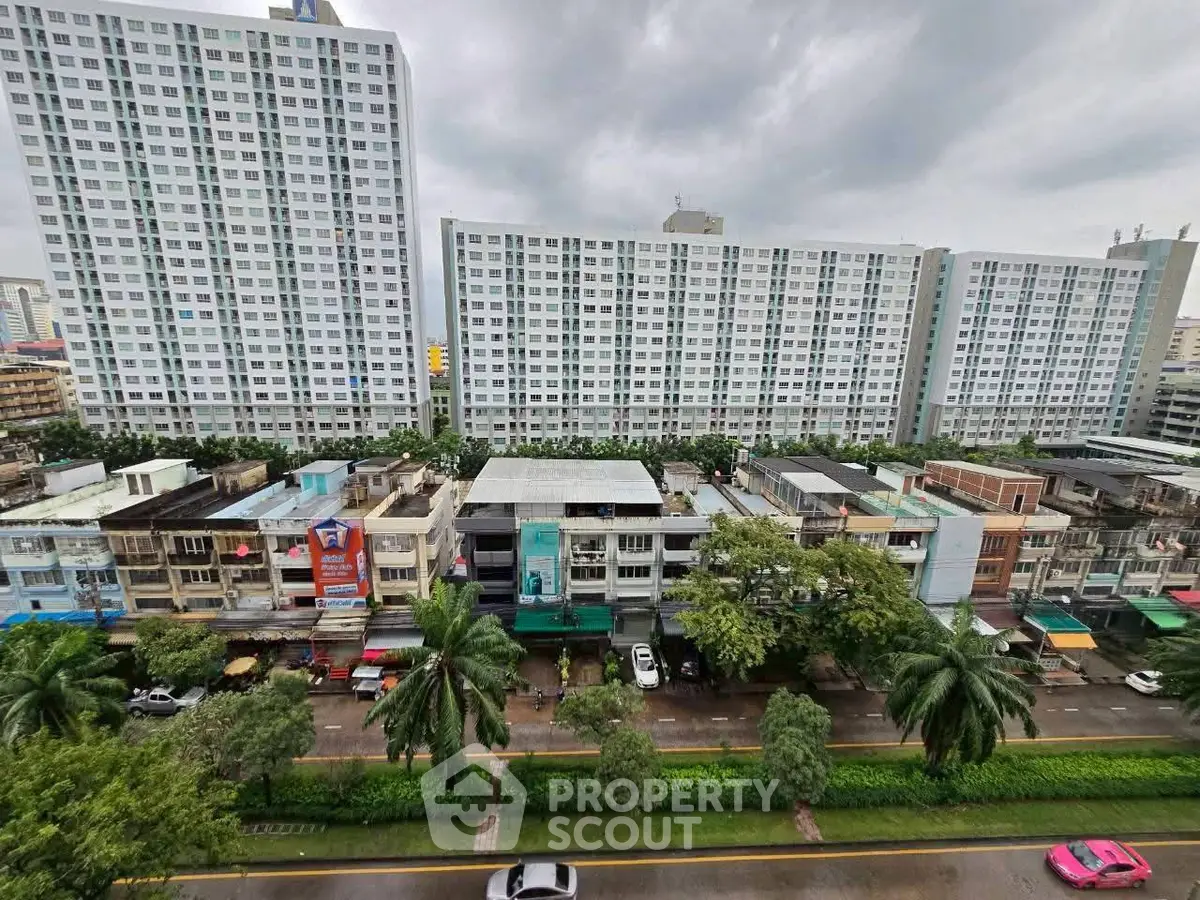 Panoramic view of modern high-rise residential buildings with lush greenery and cityscape.