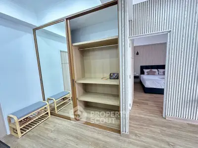 Spacious bedroom with wooden flooring and built-in wardrobe, perfect for modern living.
