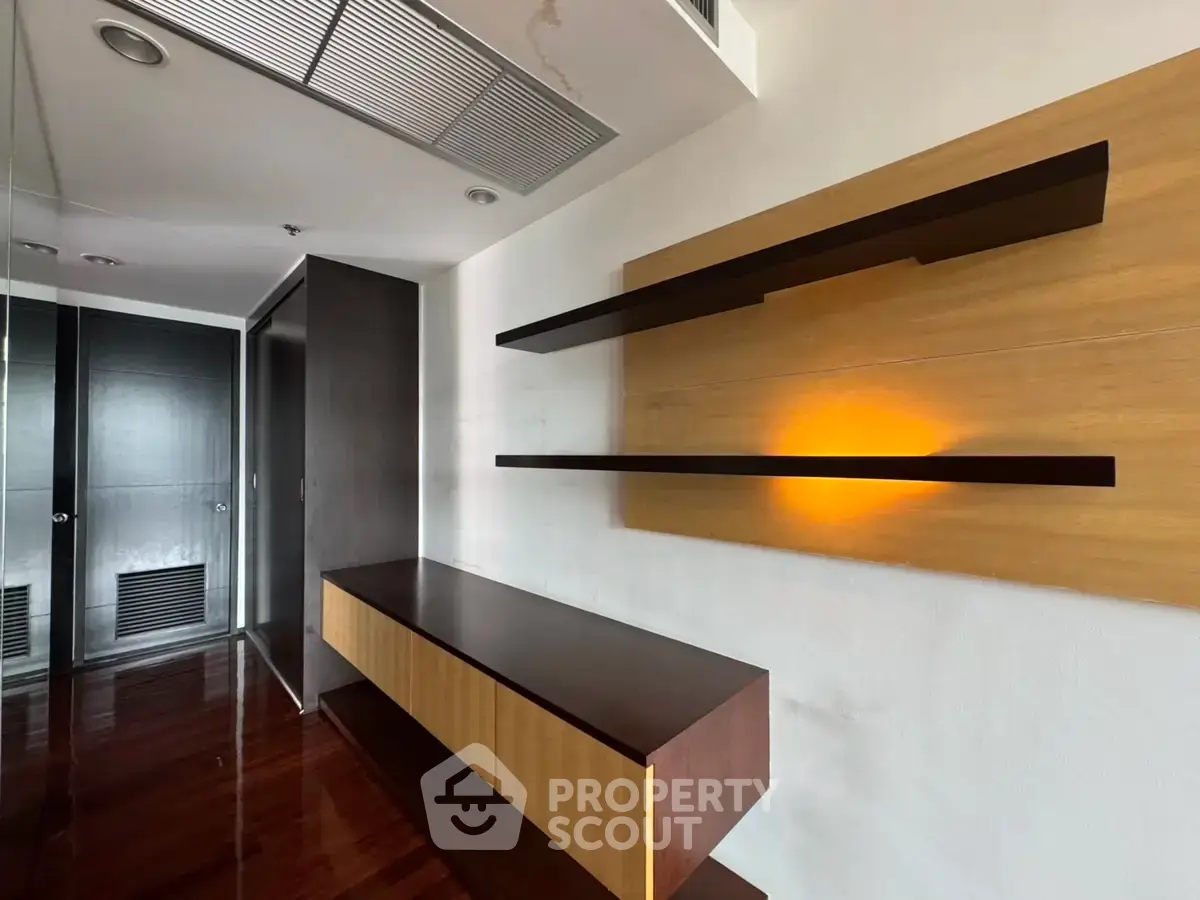 Modern interior with sleek wooden shelves and glossy flooring in a stylish apartment.