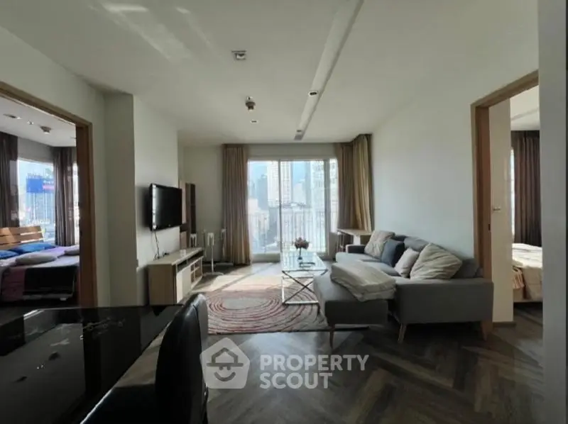 Modern living room with city view, stylish furniture, and natural light