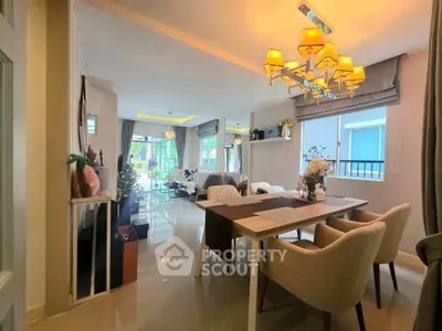 Spacious modern living and dining area with elegant lighting and large windows.