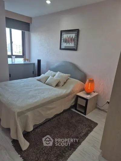 Cozy bedroom with modern decor and natural light in a stylish apartment.