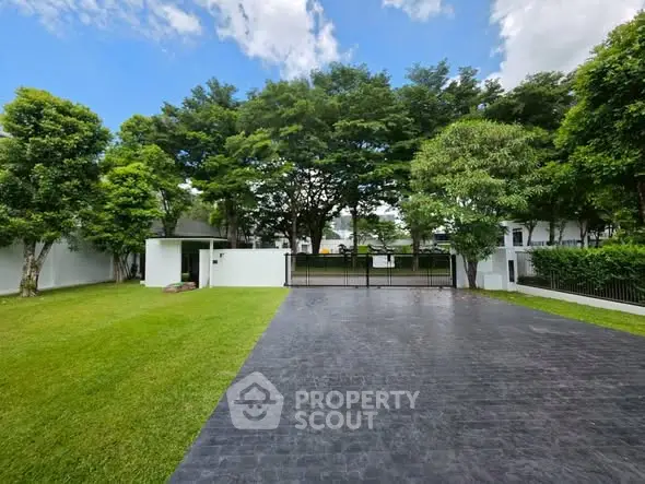 Spacious modern garden with paved driveway and lush greenery