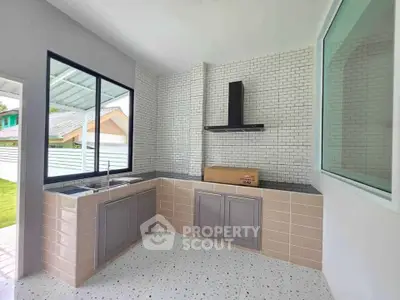 Modern kitchen with sleek cabinetry and large window offering natural light