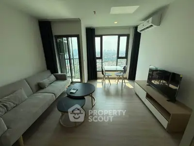 Modern living room with city view, featuring sleek furniture and large windows for natural light.