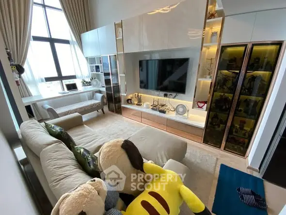 Luxurious living room with high ceilings, plush sofa, and modern entertainment center.