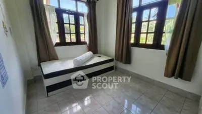 Bright bedroom with large windows and single bed, offering serene views and natural light.