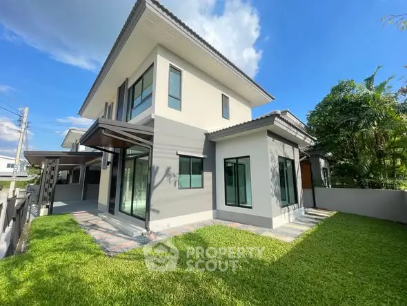 Modern two-story house with lush green lawn and large windows