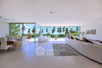 Luxurious open-plan living room with stunning ocean view and elegant decor.
