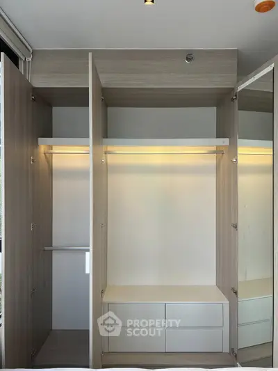 Spacious modern wardrobe with ample storage and sleek design in a contemporary bedroom.
