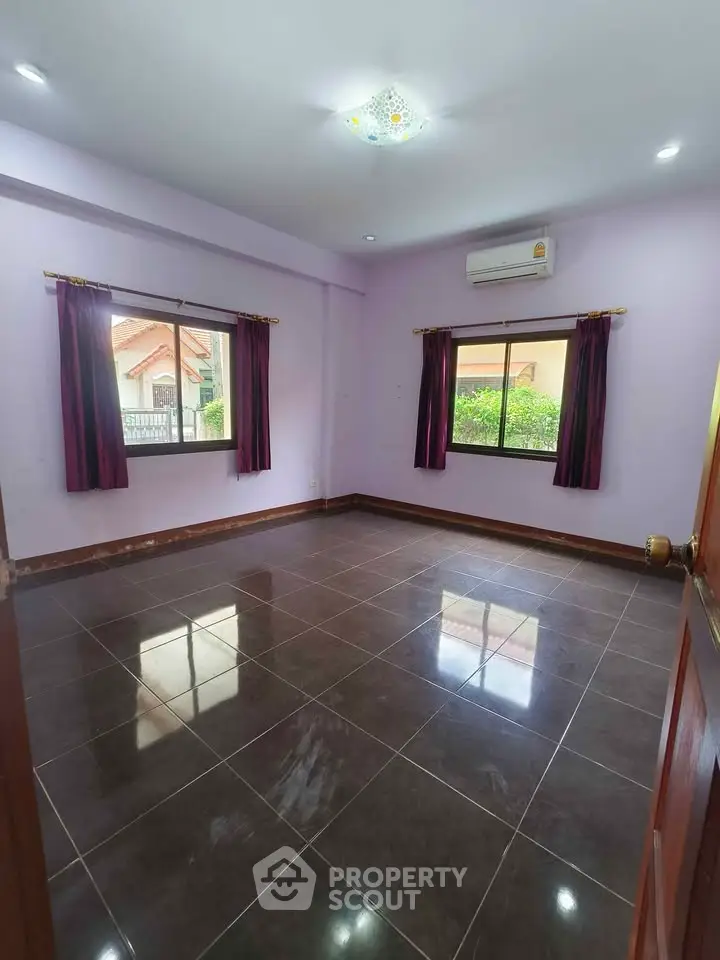 Spacious empty room with glossy tiled floor and large windows, perfect for customization.