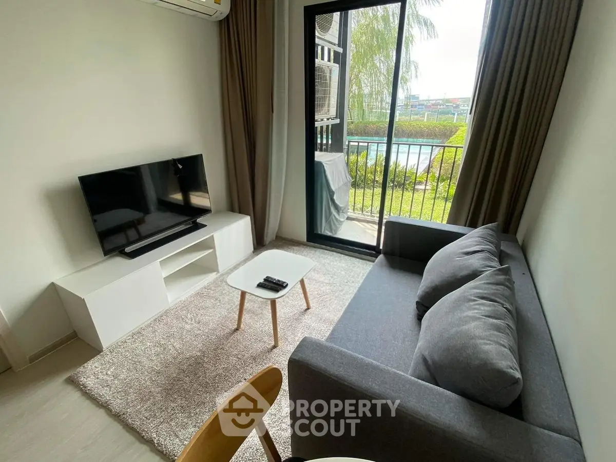 Cozy living room with modern decor and balcony view, perfect for relaxation.