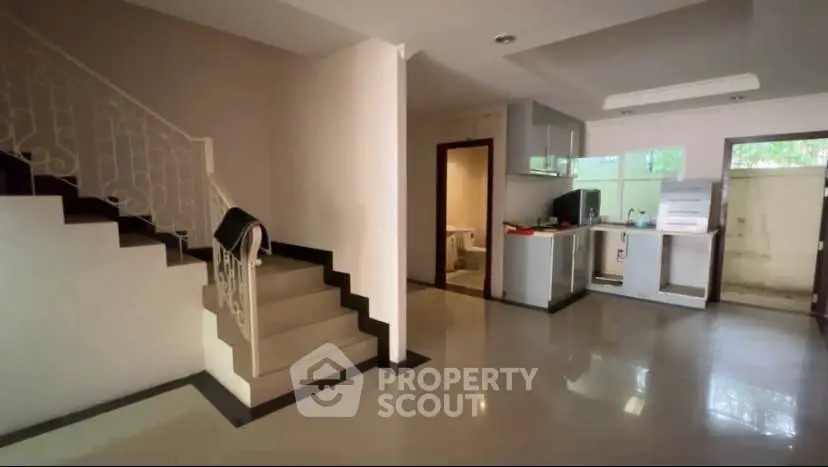 Spacious open-plan living area with modern kitchen and staircase