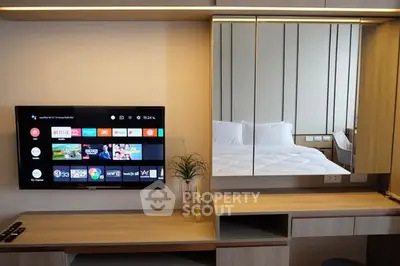 Modern bedroom with wall-mounted TV and stylish vanity mirror
