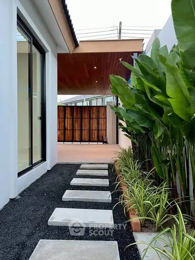 Modern home exterior with sleek pathway and lush greenery