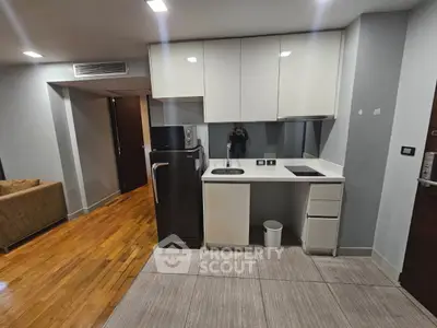 Modern compact kitchen with sleek cabinetry and integrated appliances in a stylish apartment.