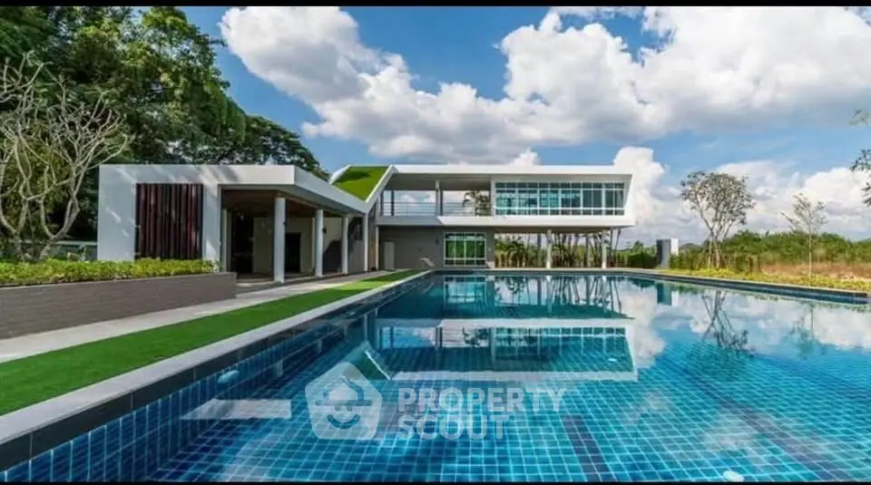 Luxurious modern villa with stunning pool and lush greenery, perfect for serene living.