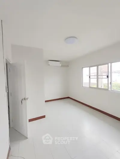 Bright and airy empty room with air conditioning and large windows.