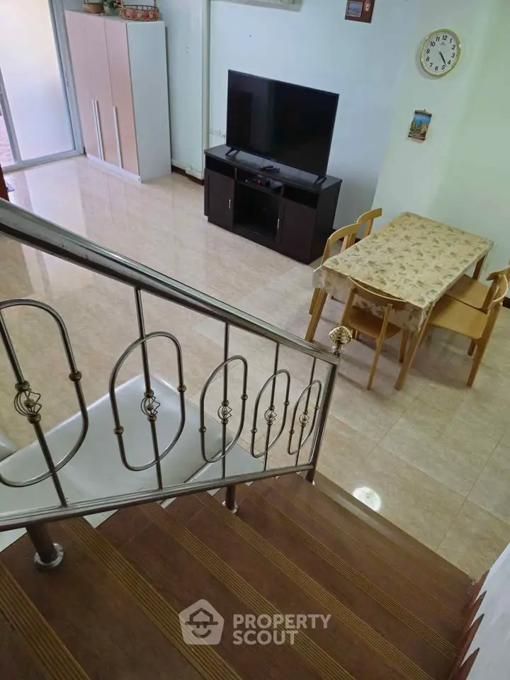 Spacious living room with modern staircase and dining area, perfect for family gatherings.