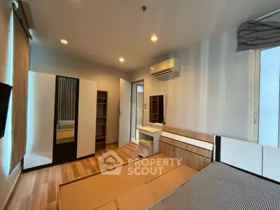 Modern bedroom with wooden flooring and built-in air conditioning