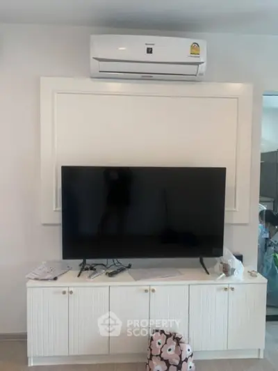 Modern living room with sleek TV setup and air conditioning unit.