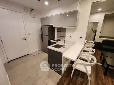 Modern kitchen with sleek cabinetry and breakfast bar in stylish apartment