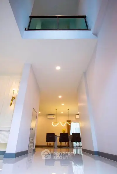 Modern interior with high ceiling and stylish dining area in contemporary home.