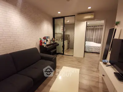 Modern living room with cozy sofa and open view to bedroom