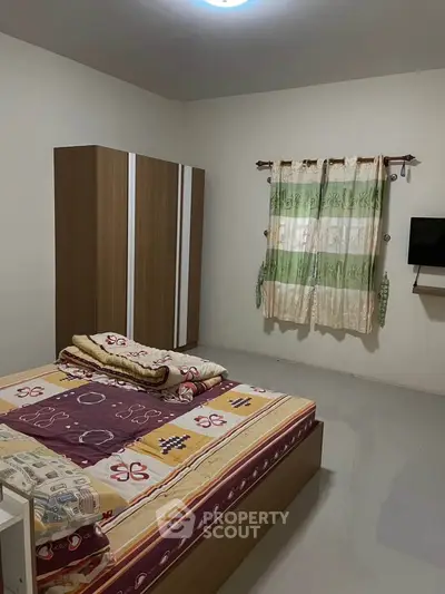 Cozy bedroom with simple decor and natural light.