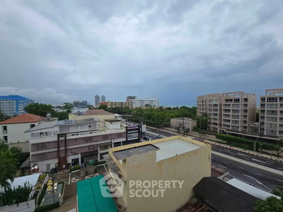 Stunning cityscape view from a high-rise building showcasing urban architecture and lush greenery.